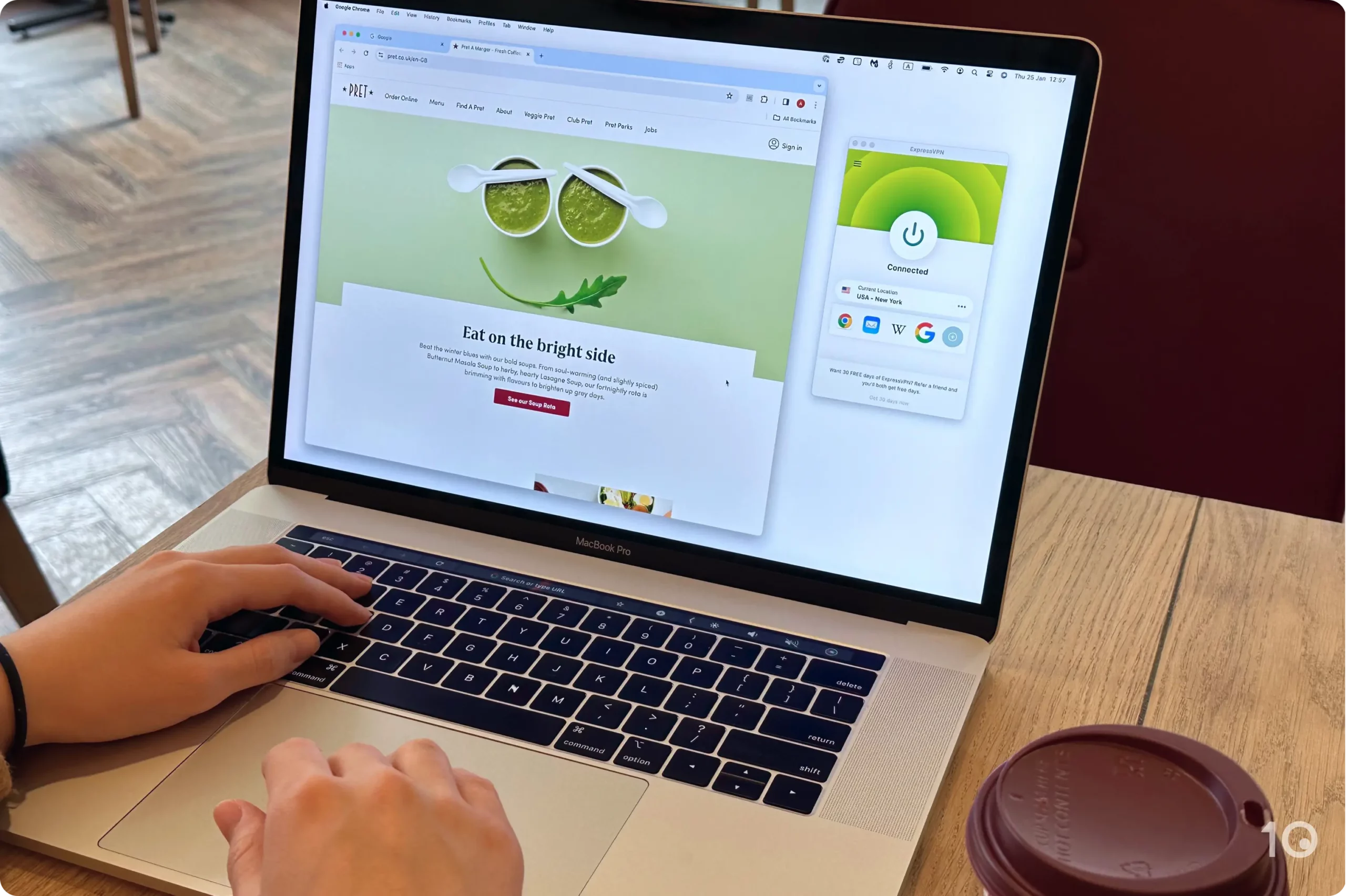In a coffee shop, a MacBook connects to public WiFi with ExpressVPN connected to a New York server.